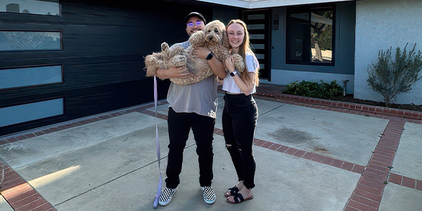 NAF's Kasey and Zo Cruz standing in front of their home