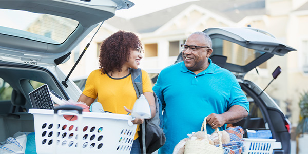 A Black man helps his daughter unload her car