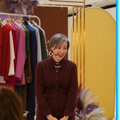 image of Canberra Centre stylist Fiona Keery in front of a rack of clothing 