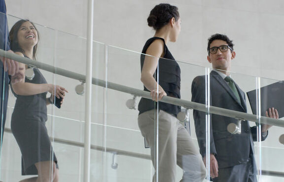 Business professionals walking down stairs in modern office