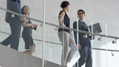Business professionals walking down stairs in modern office