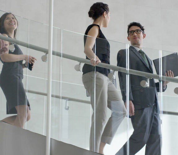 Business professionals walking down stairs in modern office