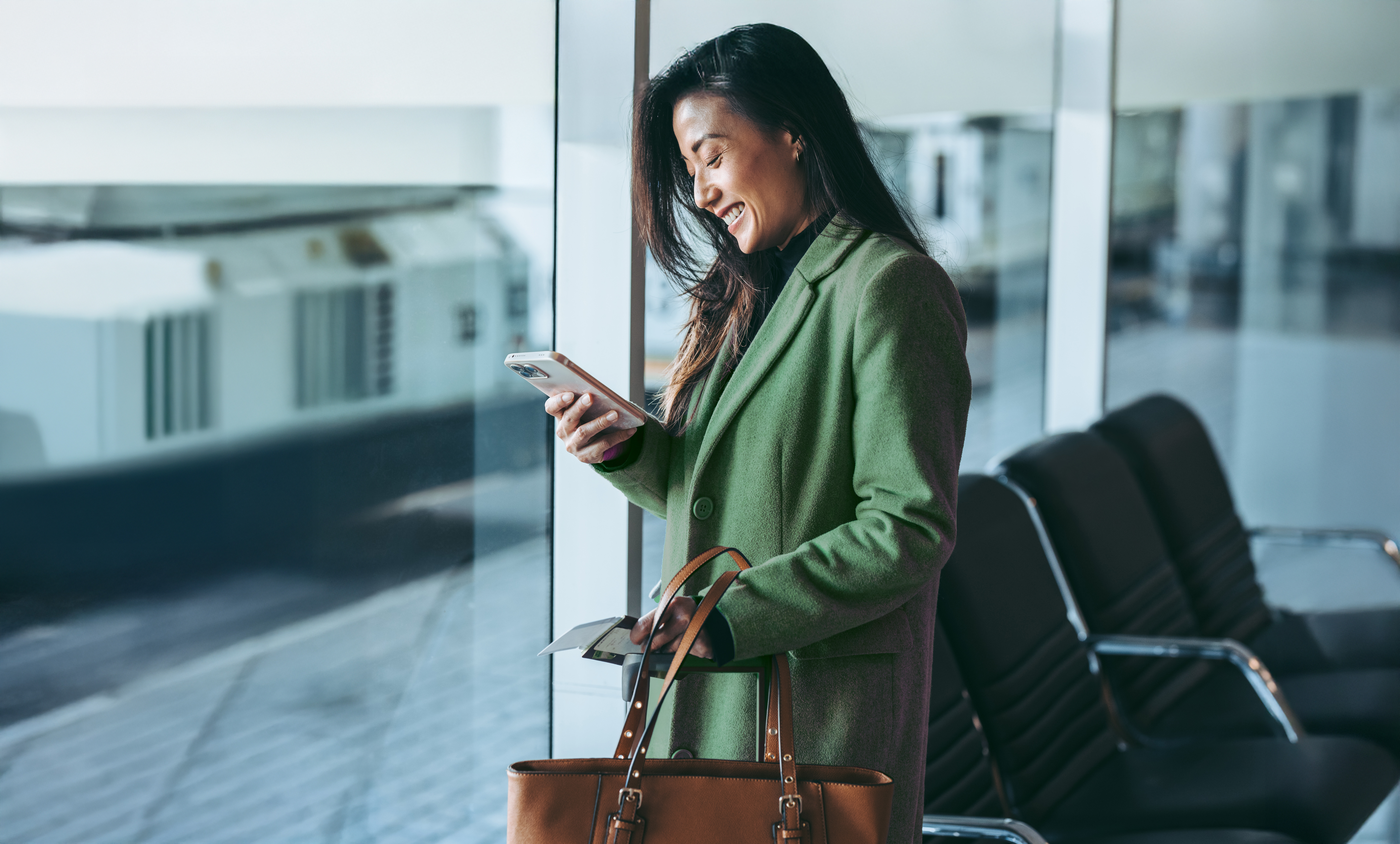 Frau am Flughafen mit Gepäck und Mobiltelefon