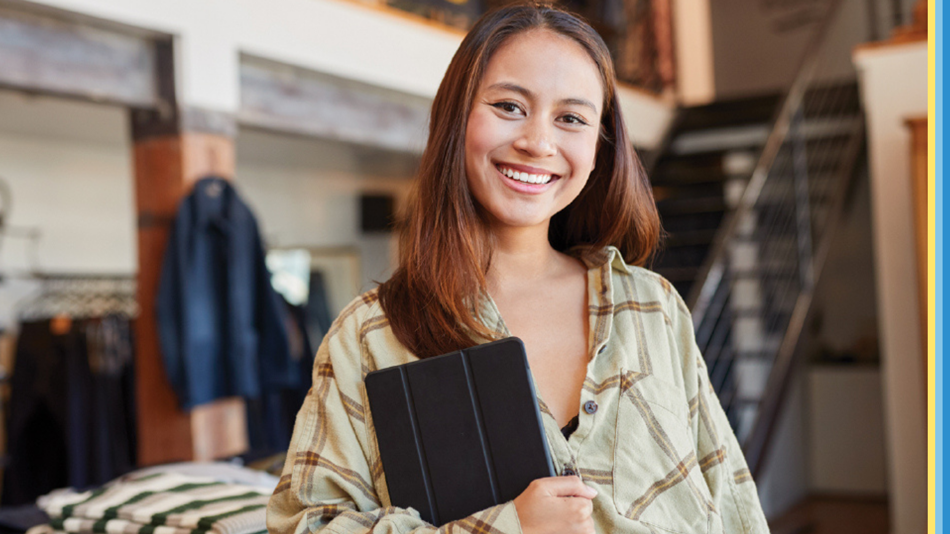 Woman holding an iPad smiling at the camera. 