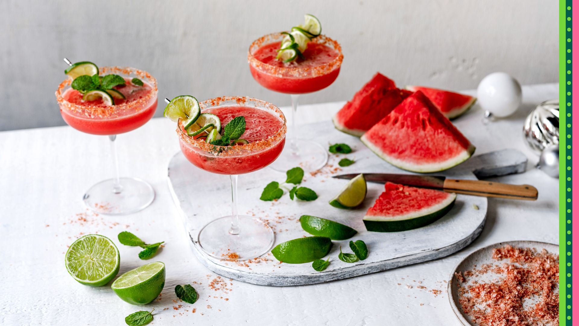 Watermelon Margarita served in champagne glasses with salted rim displayed amongst preparation area