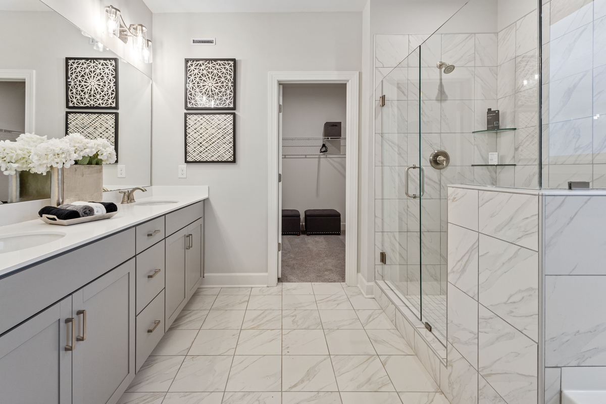 bathroom with grey cabinets and marble tile