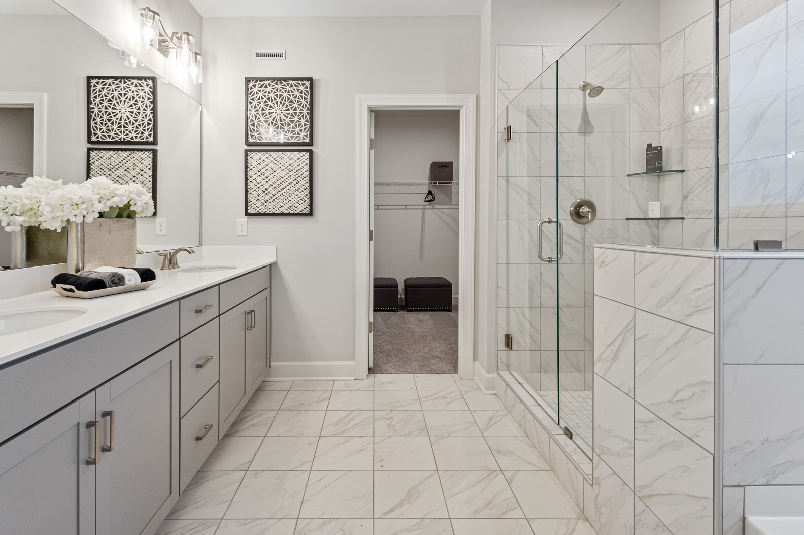 bathroom with grey cabinets and marble tile