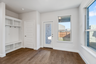 breakfast area and mud room with wood flooring, large windows, valet bench with hooks, and a glass door