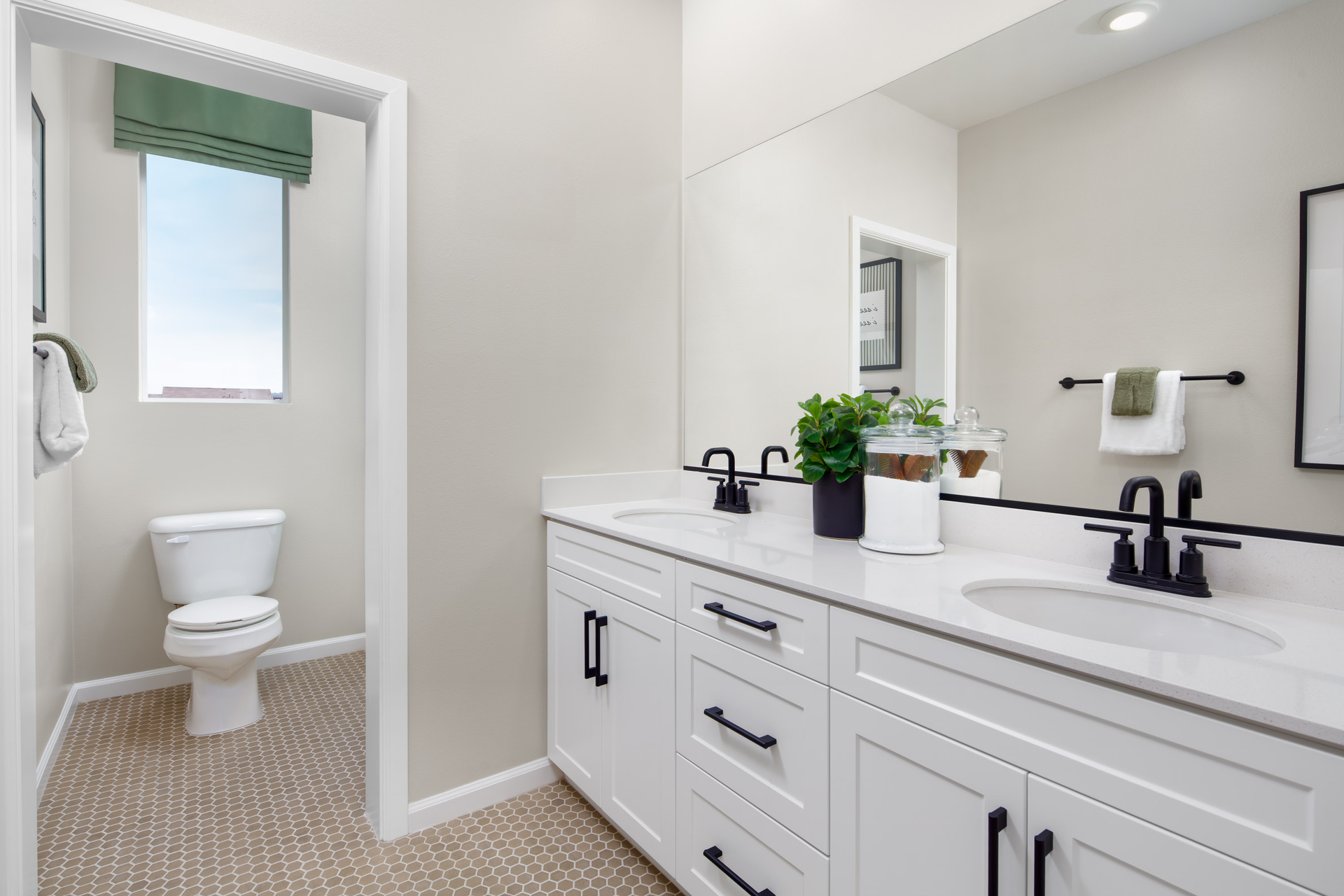 bathroom with dual sinks and private toilet
