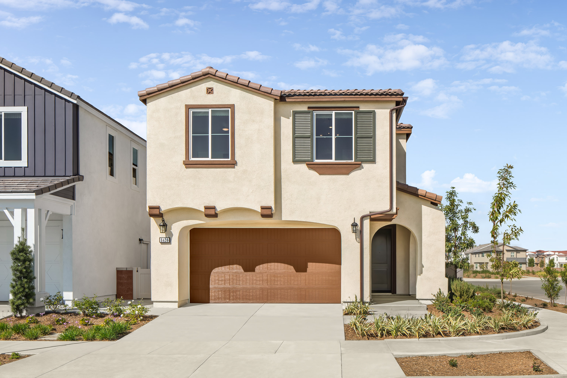 exterior of two-story house with neutral paint and desert landscaping
