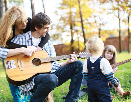 Oleh Vorobyov holds a guitar in this family portrait with his wife, Olha, and two children