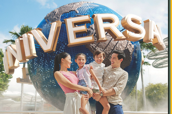 Family standing in front of Universal sign at Universal Studios Singapore