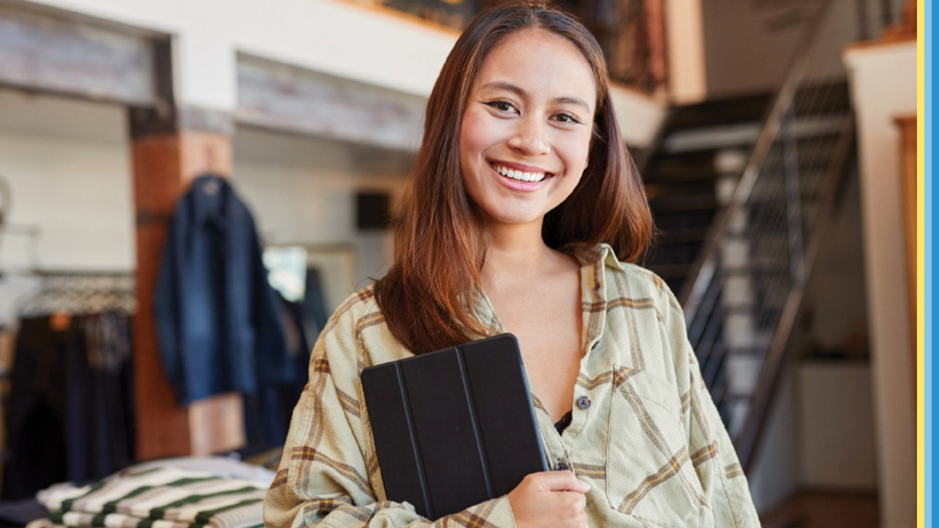 Woman holding an iPad smiling at the camera.