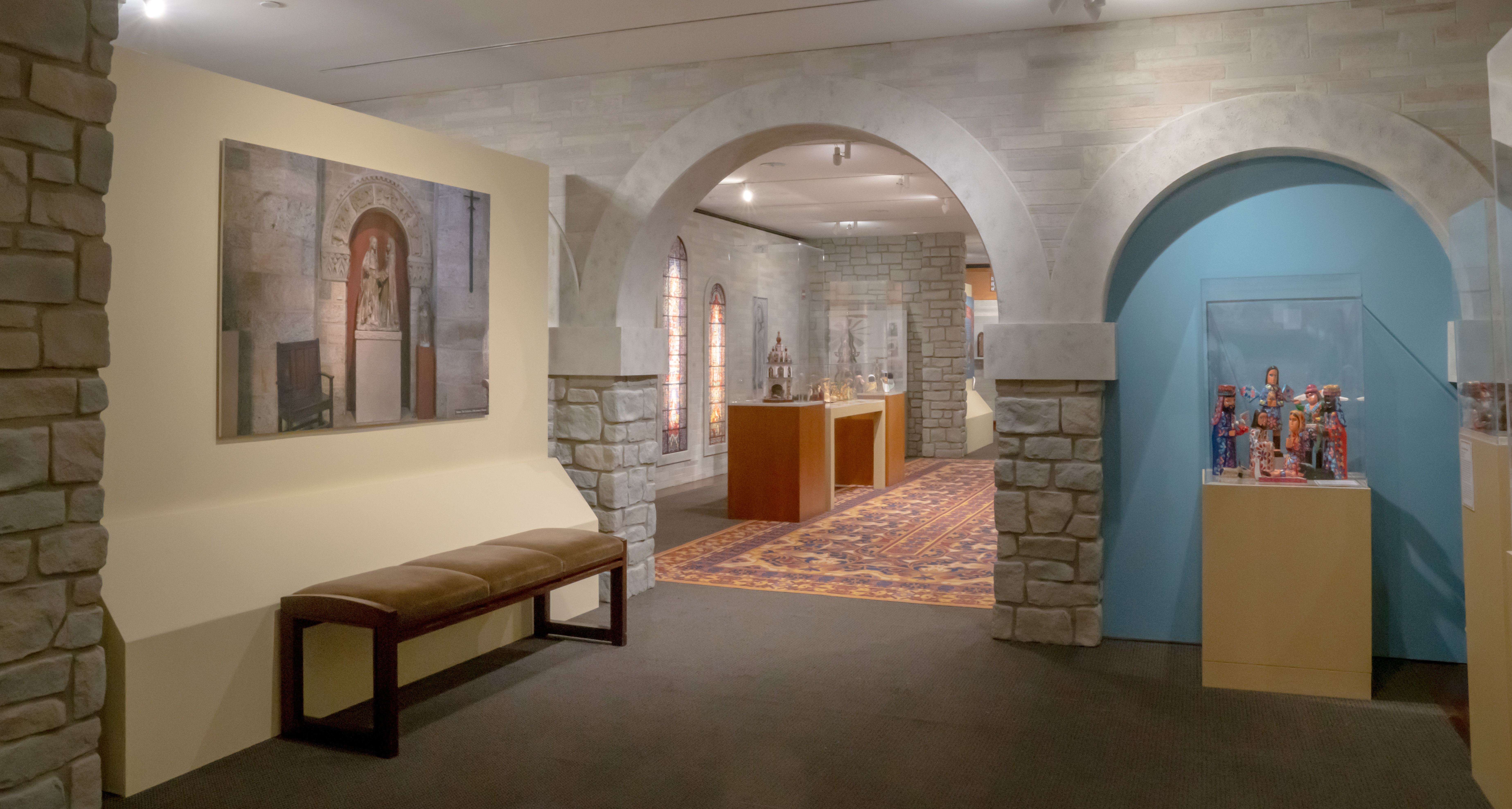 Photo of exhibit gallery featuring Nativity scenes in a faux stone castle setting inspired the architecture of Glencairn Museum.