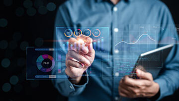 Man in a blue shirt looking at graphs and charts