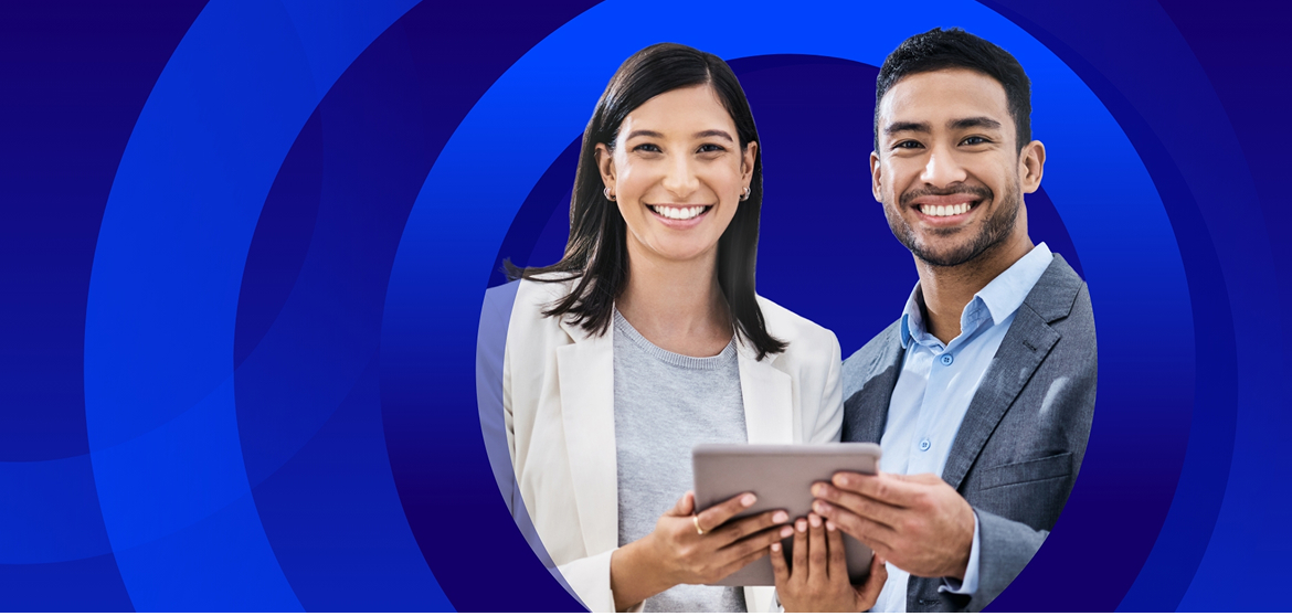 A man and a woman in business attire, both smiling, holding and looking at a tablet together. The photo is framed within a white circle and overlaid on an abstract blue background with concentric circles.