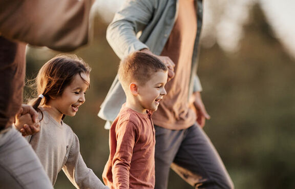 Carefree kids running with parents in the park