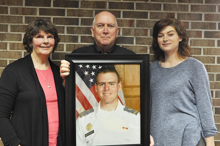 The family of the late Charlie Baldinger. His mother Kim, his father Paul, and his wife Allyson pose for a picture with his official West Point Academy portrait.