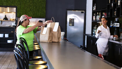 Delivery person picking up food at a counter