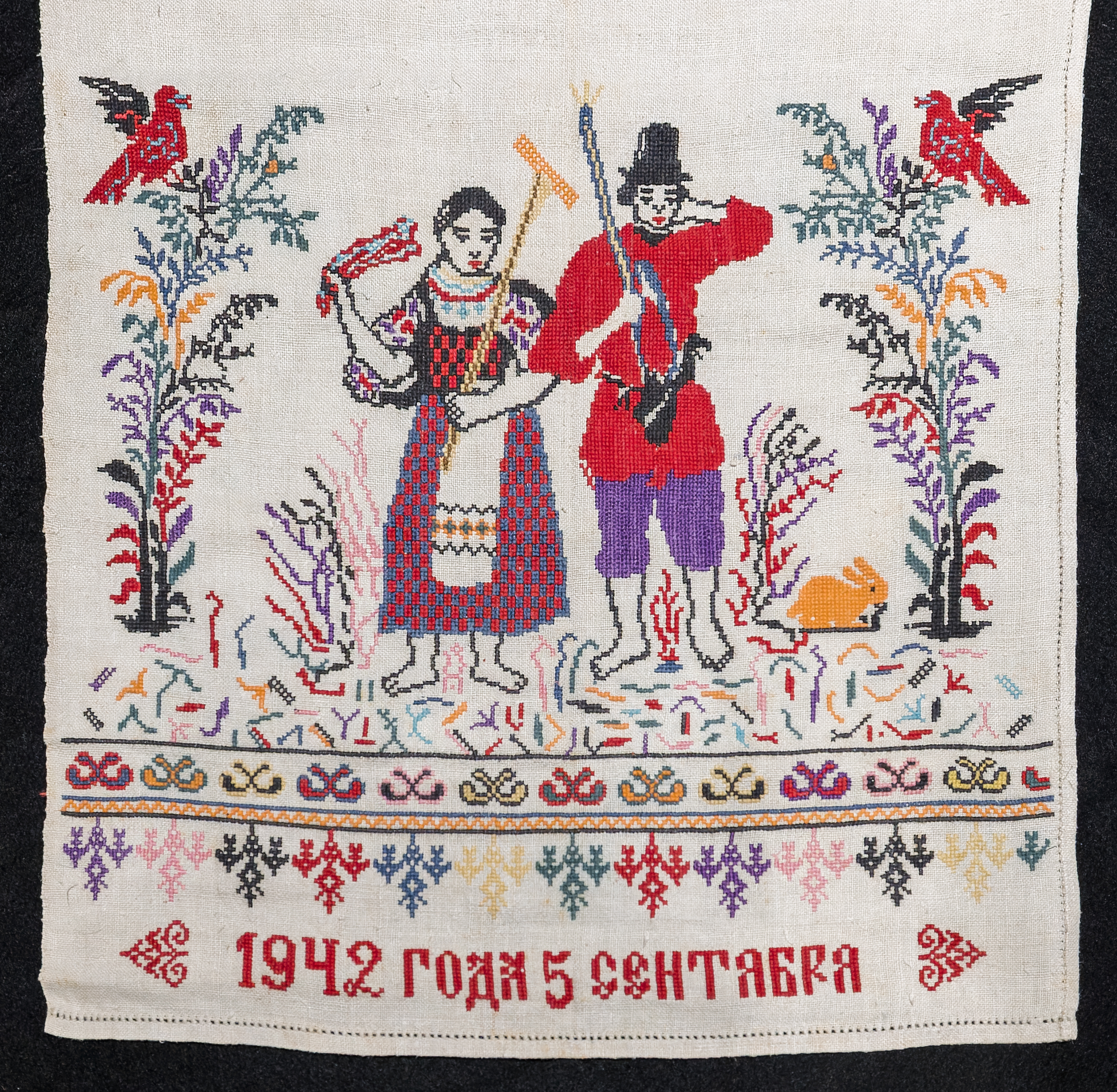 Detail image of embroidered Rushnyk from Central Ukraine depicting a man and woman off to harvest with the date “September 5, 1942” beneath. 