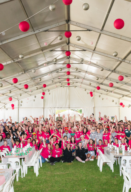 Volunteers at Christmas Lunch in the Park smiling in a group photo.