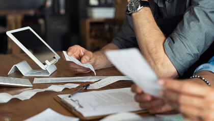 Professionals sitting at a desk filling out an expense report