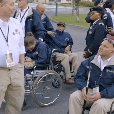 Military members and caregivers in Warriors to Lourdes uniforms partake in conversation.