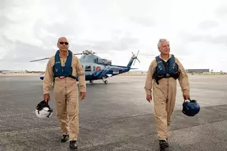 Deacon Benny Matos (left) and Anthony Marinello stand in front of the Sikorsky S-76 helicopter they flew to rescue Americans in Haiti this past March and April. (Photo by David González)