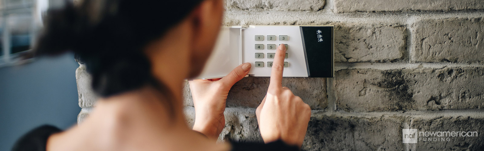 A woman puts a code into a security pad in a home