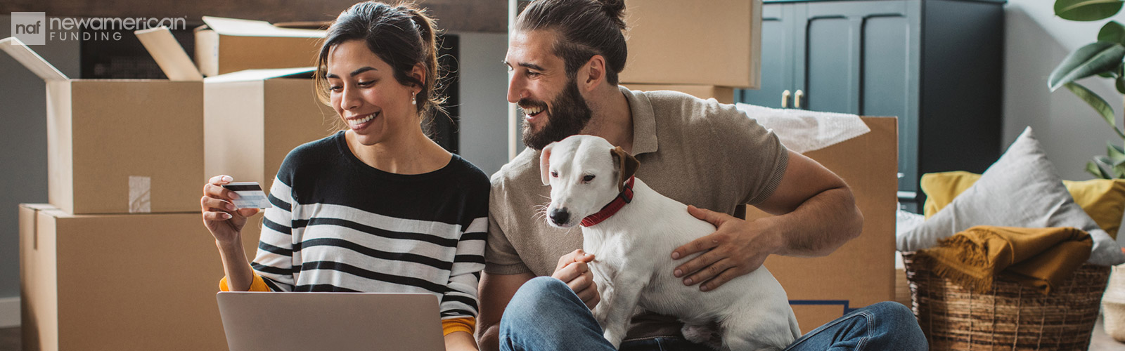 couple sitting on the floor of their new home with their dog