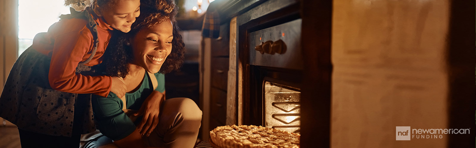 mother and daughter taking a pie out of the oven