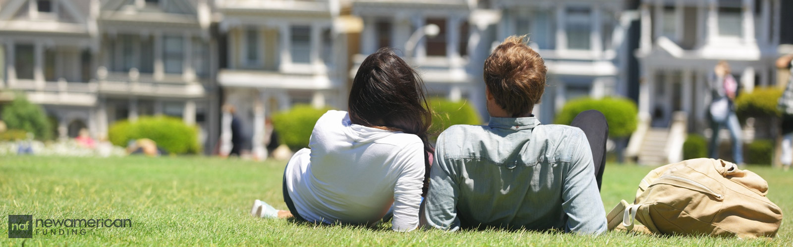 couple on the grass staring at houses