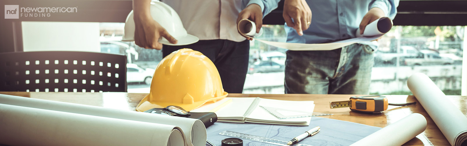 contractor plans and tools laid out on a table 