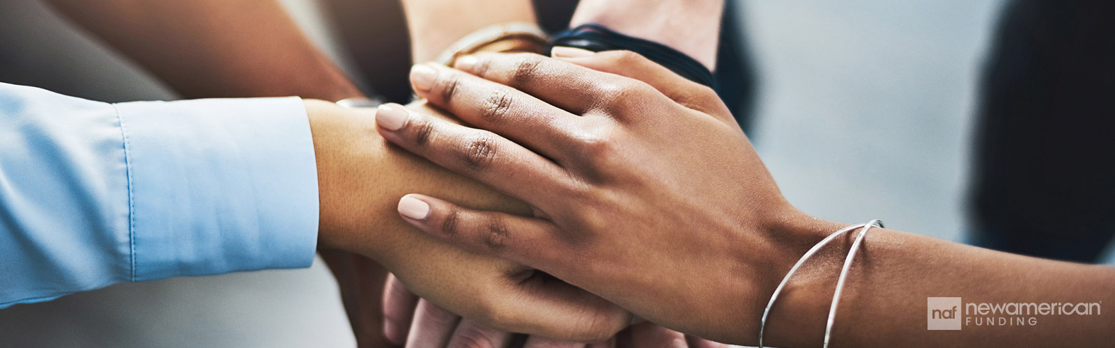 Black hands stacked on top of each other