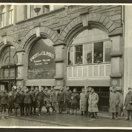 Mitliary Members pose for a photo in front of an offical KofC Army Hut recreation center in Lourdes.