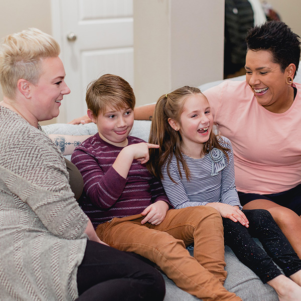 Mothers laughing with kids on couch
