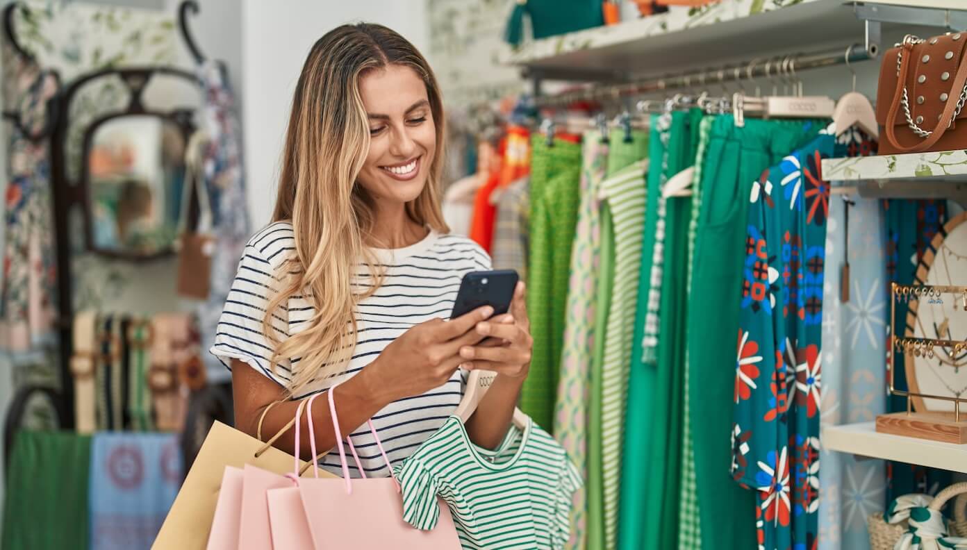 incisiv ebook image.jpg Woman holding shopping bags while looking at her smartphone.