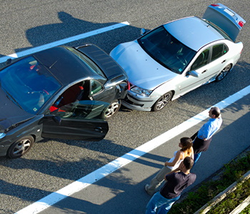 Vozniki vozil, udeleženih v prometno nesrečo, stojijo ob avtocesti in čakajo na pomoč.