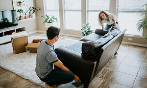 Mlad par prinaša svoje pohištvo v najeto stanovanje.