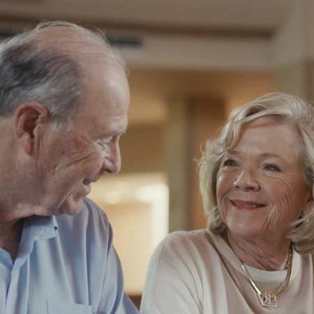 An elderly couple enjoying a meal together at a restaurant, sharing a special moment in their lives.