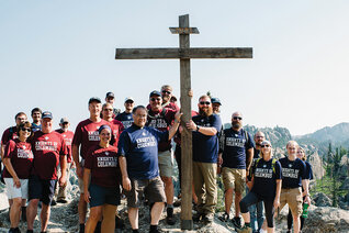 K of C pilgrims stand with the cross they carried to the summit of Black Elk Peak to honor the Lakota holy man and pray for his canonization and intercession.