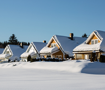Vrstne hiše je prekrila debela snežna odeja, ki ogroža trdnost njihovih ostrešij.