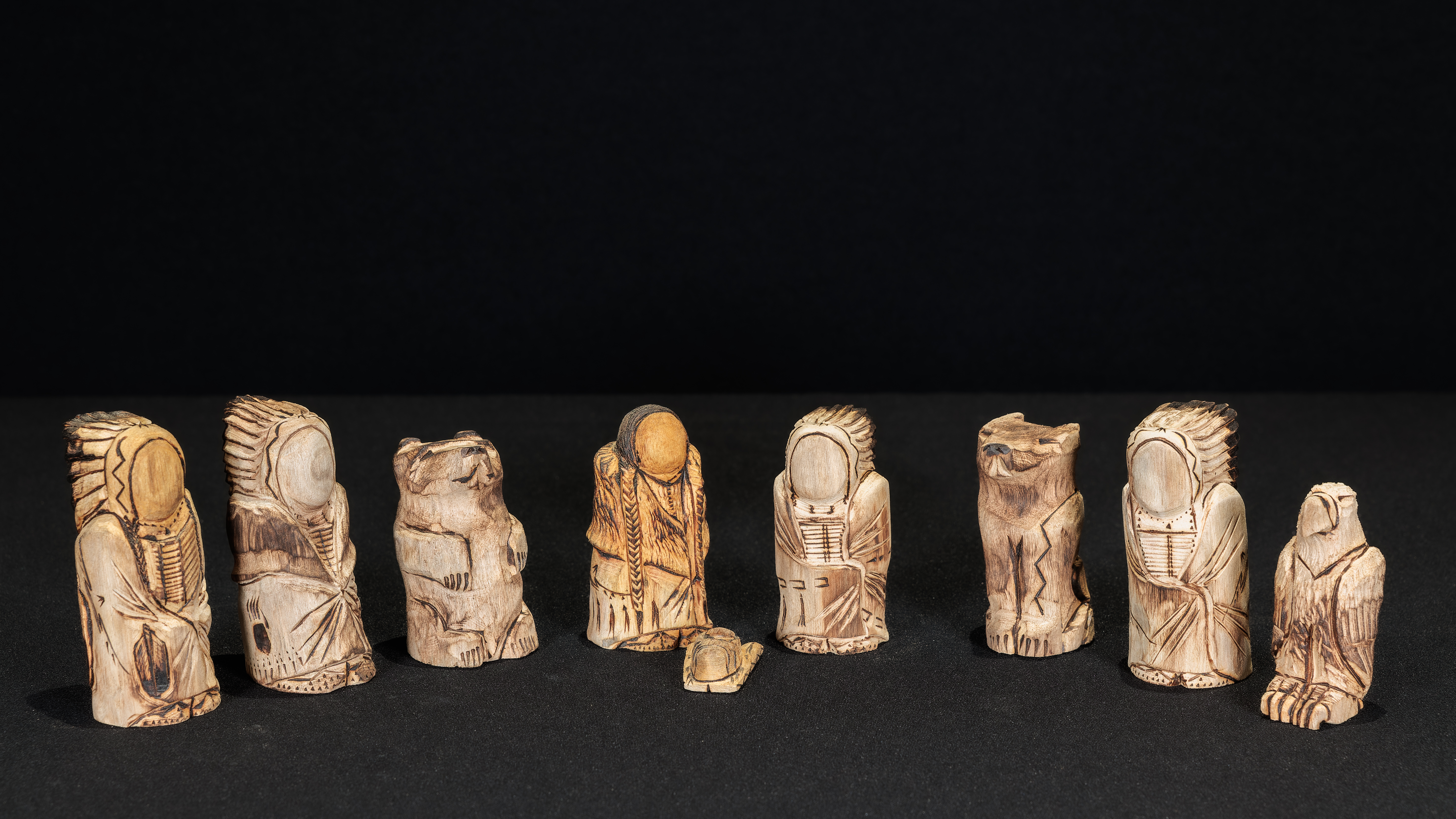 Wood carved Lakota Nativity scene with the Holy Family and three Magi in indigenous clothing. Also included is figures of an eagle, wolf, and bear.