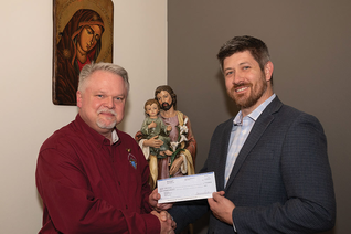 Texas State Life Director Tom Clark delivers a check for $30,000 to Aaron Fowler, Birth Choice’s executive director