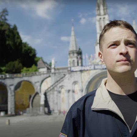 Man stands proudly looking off into distance wearing WTL apparel in Lourdes