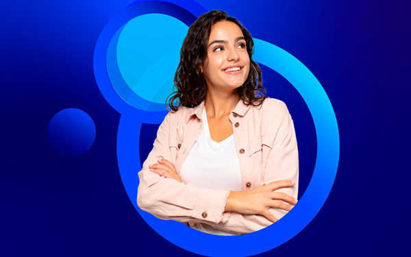 A young woman with dark, curly hair smiles and looks up and to the right, standing with her arms crossed. She is wearing a light pink jacket over a white shirt. The background is a bright blue with faint concentric blue circles.