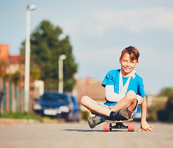 Nezgode otrok so se zgodijo hitro - na sliki otrok z roko v mavcu na rolki.
