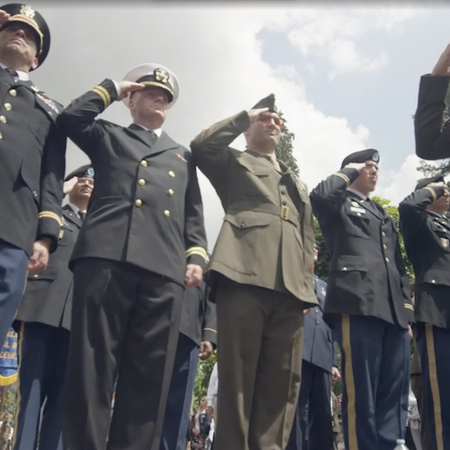 Military members from an array of uniforms from different military branches solute