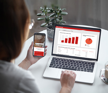 Ženska na računalniku in telefonu z Moj GENERALI pregleduje svoje zavarovalne police.