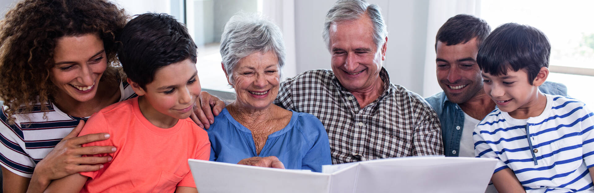 multi-generational family looks through notebook